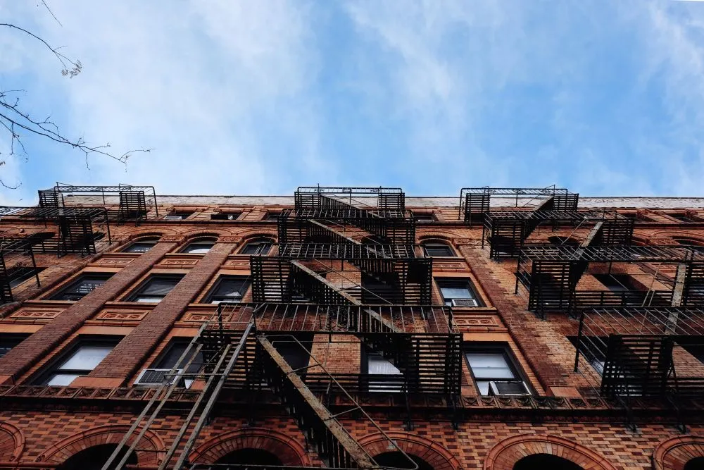 Façade en briques rouges avec escaliers extérieurs métalliques typiques de Manhattan