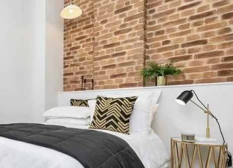 Chambre avec lit double et mur en briques apparentes