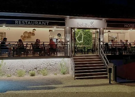 Façade du restaurant-hôtel Bellevue illuminée en soirée avec terrasse extérieure