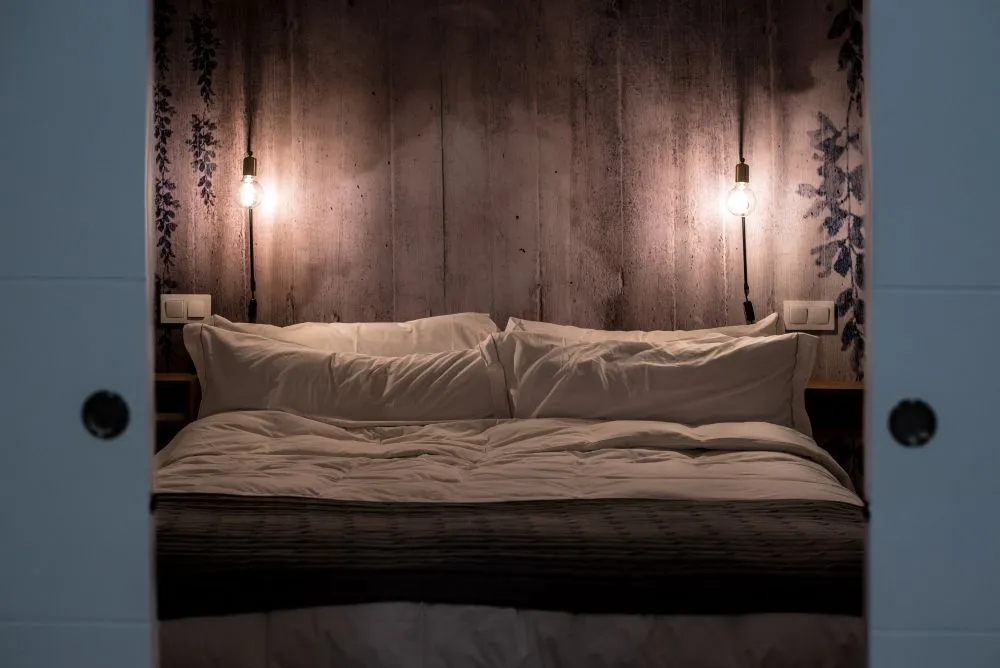 Chambre moderne avec un mur derrière le lit en béton lisse.